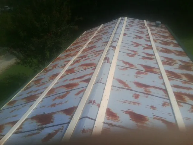 Rusted metal roof panels with new wood purlins before replacement — Storm Damage Roof Repair in Bertha by Roofing Brothers